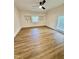 Bright bedroom featuring wood-look floors, large window, white walls, and a ceiling fan at 41 Lakewood Dr, Roxboro, NC 27573
