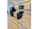 Well-lit kitchen with white cabinets, stainless steel appliances, and granite countertops at 41 Lakewood Dr, Roxboro, NC 27573