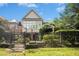 Well-manicured backyard with paver stone patio, lush greenery, and mature trees, perfect for outdoor living at 4137 Gardenlake Dr, Raleigh, NC 27612