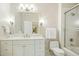 Elegant bathroom features a white vanity, large mirror, shower with glass door, and white tiled floor at 4137 Gardenlake Dr, Raleigh, NC 27612