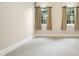 Cozy bedroom with neutral carpet, white trim, and natural light from two windows with decorative curtains at 4137 Gardenlake Dr, Raleigh, NC 27612