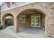 Beautiful brick arches frame the covered patio, offering a charming outdoor living space with access to the home at 4137 Gardenlake Dr, Raleigh, NC 27612