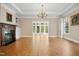 Living room features a fireplace, hardwood floors, chandelier, custom built-in cabinets, and decorative window at 4137 Gardenlake Dr, Raleigh, NC 27612