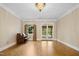 Bright living room with parquet floors, a piano, and French doors leading outside at 4137 Gardenlake Dr, Raleigh, NC 27612