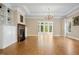 Living room features a chandelier, fireplace, hardwood floors, large window and custom built-in cabinets at 4137 Gardenlake Dr, Raleigh, NC 27612