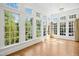 Sun room features large windows with views of greenery and hardwood floors at 4137 Gardenlake Dr, Raleigh, NC 27612