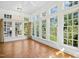 Bright sun room features large windows with views of greenery and hardwood floors at 4137 Gardenlake Dr, Raleigh, NC 27612
