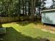 A backyard with mature trees and an outbuilding beyond the fence, perfect for relaxing at 424 Shawnee Dr, Louisburg, NC 27549