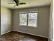 Neutral bedroom with hardwood floors, a ceiling fan, and a view of the fenced backyard through double windows at 424 Shawnee Dr, Louisburg, NC 27549
