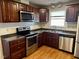 Well-lit kitchen featuring stainless steel appliances and dark wood cabinets at 424 Shawnee Dr, Louisburg, NC 27549