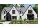 Stunning new construction featuring a white brick facade, sleek black trim, and manicured landscaping at 4348 Coldwater Springs Dr, Raleigh, NC 27616