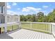 Relaxing deck with gray flooring and white railing overlooking the lush backyard at 44 Clarke Ct, Angier, NC 27592