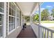 Covered front porch featuring a wood floor and a white decorative railing and columns at 44 Clarke Ct, Angier, NC 27592