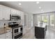 Modern kitchen featuring stainless steel appliances, white cabinets, and an eat-in island at 44 Clarke Ct, Angier, NC 27592
