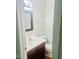 Cozy half-bath featuring a wood vanity and a framed mirror above the sink at 4418 Roller Ct, Raleigh, NC 27604