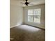 Neutral carpeted bedroom with a ceiling fan and a large window at 4418 Roller Ct, Raleigh, NC 27604