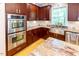 Modern kitchen features stainless steel double ovens, and sink, complemented by tile backsplash at 5240 Indigo Moon Way, Raleigh, NC 27613