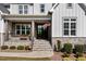 Inviting front porch with stone accents, black door, and American flag, creating a warm welcome at 623 Westfall Way, Chapel Hill, NC 27517