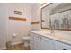 Bathroom with a white vanity, framed mirror, and wallpaper at 6308 Rolling Acres Drive, Gibsonville, NC 27249
