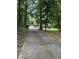 Long driveway to a charming brick home with blue shutters, offering privacy and curb appeal at 6308 Rolling Acres Drive, Gibsonville, NC 27249
