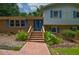 Charming brick home featuring a brick walkway, front stairs, and vibrant blue doors at 6308 Rolling Acres Drive, Gibsonville, NC 27249