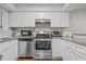 Updated kitchen featuring stainless steel appliances, white cabinets, and granite countertops at 7020 Longstreet Dr # A, Raleigh, NC 27615