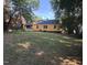 Spacious backyard featuring a well-maintained lawn and mature trees, yellow siding on home at 719 E Whitaker Mill Rd, Raleigh, NC 27608