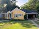 Charming yellow home with green shutters, covered parking, and a well-manicured lawn at 719 E Whitaker Mill Rd, Raleigh, NC 27608