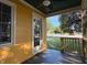 Covered porch with ceiling fan overlooking the front lawn, freshly painted yellow siding at 719 E Whitaker Mill Rd, Raleigh, NC 27608