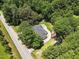 An aerial view of the house, illustrating its placement among green trees and the proximity to the road at 7722 Nc 27, Lillington, NC 27546