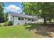 Spacious backyard showcasing a well-maintained lawn, mature trees, and the home's exterior at 7722 Nc 27, Lillington, NC 27546