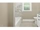 Bathroom featuring a soaking tub with tiled walls and ample natural light at 7722 Nc 27, Lillington, NC 27546