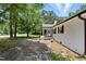 Exterior view of a white brick home with a front porch and mature trees at 7722 Nc 27, Lillington, NC 27546
