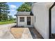 View of a side door with stone base and gravel, offering additional home access from the driveway at 7722 Nc 27, Lillington, NC 27546
