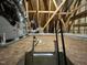 Attic access with pull-down ladder, wooden beams, and plywood flooring for storage at 8836 Thornton Garden Ln, Raleigh, NC 27616
