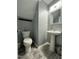 Powder room with pedestal sink, modern mirror, and neutral grey color scheme at 8836 Thornton Garden Ln, Raleigh, NC 27616