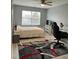 Bedroom features a ceiling fan, neutral walls, a large window, and a patterned area rug at 8836 Thornton Garden Ln, Raleigh, NC 27616