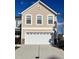 Exterior shot of a two-car garage with white door, beige siding, and white trim around windows at 8836 Thornton Garden Ln, Raleigh, NC 27616