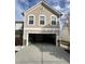 View of an open two-car garage with visible interior items and beige siding exterior at 8836 Thornton Garden Ln, Raleigh, NC 27616