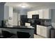 Kitchen with black countertops, black appliances, backsplash and white cabinets at 8836 Thornton Garden Ln, Raleigh, NC 27616