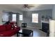 Living room featuring fireplace, gray walls, light floors, and open view to dining area at 8836 Thornton Garden Ln, Raleigh, NC 27616