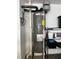 Water heater and piping in a utility room with shelving for organized storage at 8836 Thornton Garden Ln, Raleigh, NC 27616