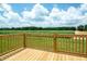 View of the wooden porch with wooden railings overlooking a green field at 100 Cottonwood Ct, Kenly, NC 27542
