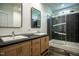 Modern bathroom featuring a double vanity with dark countertop and tiled shower with glass door at 100 Cottonwood Ct, Kenly, NC 27542