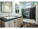 Modern bathroom featuring a double vanity with dark countertop and tiled shower with glass door at 100 Cottonwood Ct, Kenly, NC 27542
