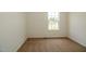 Empty bedroom featuring tan carpet and a window with backyard view at 100 Cottonwood Ct, Kenly, NC 27542