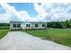 Gravel driveway leading to a beige manufactured home with a covered front porch at 100 Cottonwood Ct, Kenly, NC 27542