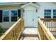 Inviting front door with wooden steps, porch, and sleek exterior lighting at 100 Cottonwood Ct, Kenly, NC 27542