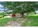 Backyard featuring a lush lawn, a large shade tree, and horse amenities, perfect for country living and outdoor activities at 1007 Windward Hill Ct, Middlesex, NC 27557