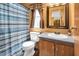 Small bathroom with blue striped shower curtain and dark wood cabinets at 1007 Windward Hill Ct, Middlesex, NC 27557